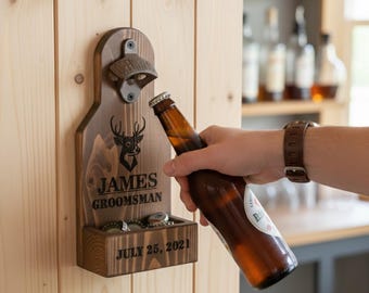 May include: A wooden bottle opener with a metal opener and a small tray for bottle caps. The opener is mounted on a wooden board with the text "JAMES GROOMSMAN JULY 25, 2021" and a deer head graphic. A person is opening a beer bottle.