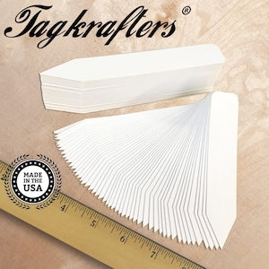May include: A stack of 50 white plant labels, each measuring approximately 2.5 inches long. The labels are made in the USA and are perfect for labeling plants in a garden or home.