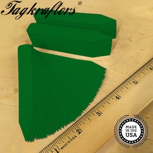 May include: A stack of 100 green plant markers, approximately 3 inches long, with a pointed end. The markers are made in the USA.