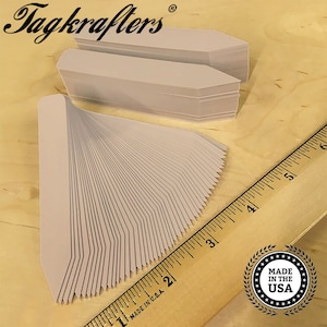 May include: A stack of 50 blank, white plant markers with a pointed end. The markers are arranged in a fan shape and measure approximately 2 inches in length. The markers are made in the USA.