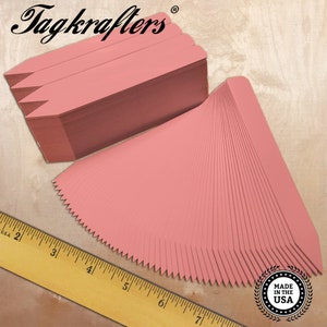 May include: A stack of 100 pink plant markers, each measuring 2.5 inches long, with a pointed tip. The markers are made in the USA and are ideal for labeling plants in a garden or greenhouse.
