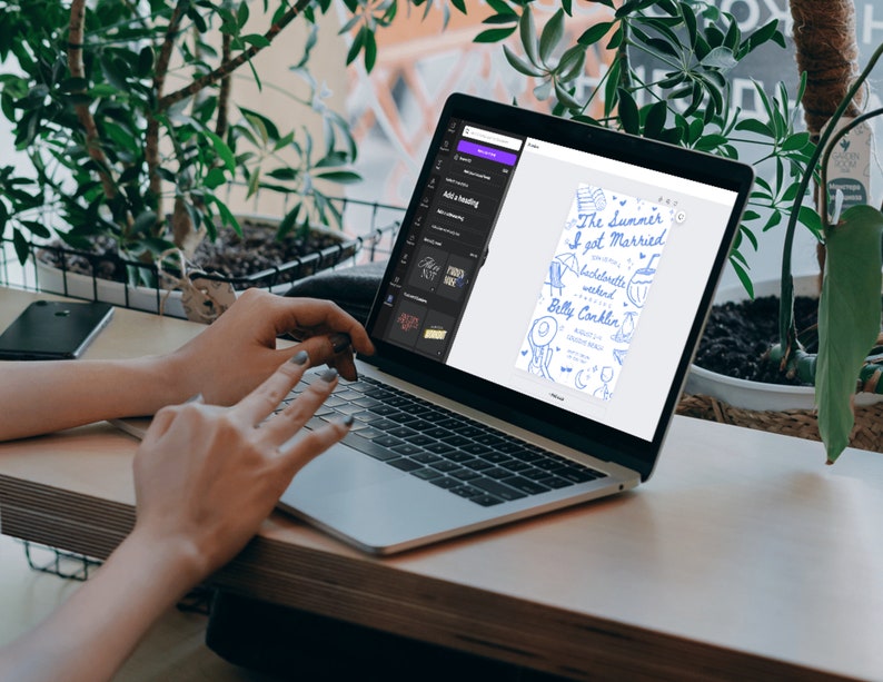 May include: A laptop computer displaying a digital design for a wedding invitation. The invitation is blue and white with hand-drawn illustrations of a beach scene and the text "The Summer I got Married".