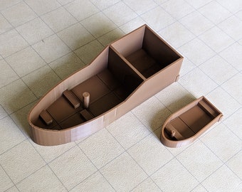 Könnte beinhalten: Zwei braune 3D-gedruckte Miniaturboote. Das größere Boot hat ein rechteckiges Abteil und einen geschwungenen Rumpf. Das kleinere Boot hat einen geschwungenen Rumpf und ein einzelnes Abteil.