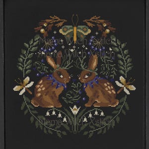 Può includere: Schema di punto croce con due conigli marroni con colletti floreali blu, una farfalla e una ghirlanda di fiori su sfondo nero. Lo schema è intitolato "Mama Witch Xstitch".