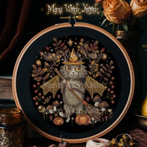 Puede incluir: Un patrón de punto de cruz con un gato gris que lleva un sombrero de bruja y sostiene una escoba. El gato está rodeado de hojas de otoño, setas y calabazas. El patrón está enmarcado en un aro de madera oscura. El texto "Mama Witch Xstitch" es visible en la parte superior de la imagen.