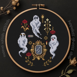 May include: A cross-stitch design featuring a black background with white ghosts, red roses, and gold accents. The design includes a mirror, candles, and the text "hopeless ghosts club" and "mama witch xstitch". The design is set in a wooden embroidery hoop.