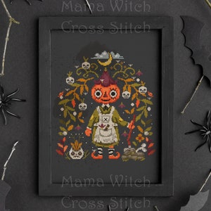May include: Cross stitch pattern of a pumpkin witch holding a broom and standing in a garden with skulls, flowers, and a crescent moon. The pattern is framed in a black frame and the text "Mama Witch Cross Stitch" is printed on the frame.