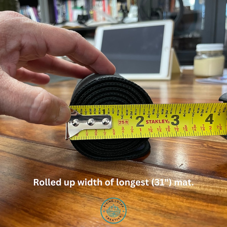 May include: A black yoga mat rolled up and measured with a yellow tape measure. The tape measure reads 31 inches. The text "Rolled up width of longest (31") mat." is below the image.