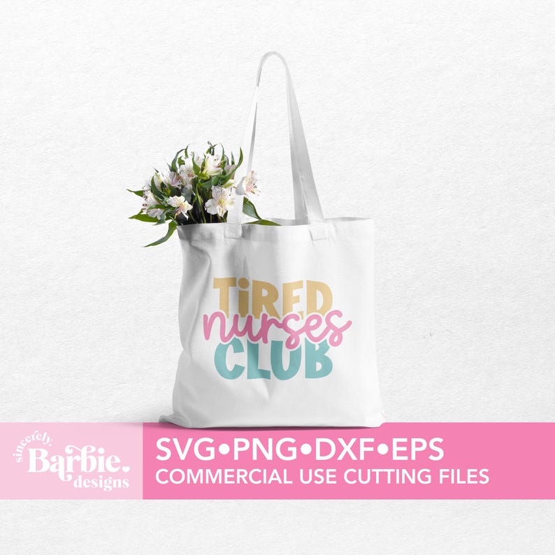 Może przedstawiać: Biała torba typu tote bag z napisem "TIRED NURSES CLUB" w kolorze ż&oacute;łtym, r&oacute;żowym i niebieskim. Torba leży na r&oacute;żowym tle, a za nią znajduje się bukiet białych kwiat&oacute;w.