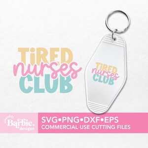 Może przedstawiać: Biały brelok do kluczy z jasnoniebieskim, r&oacute;żowym i ż&oacute;łtym wzorem z napisem "TIRED NURSES CLUB".
