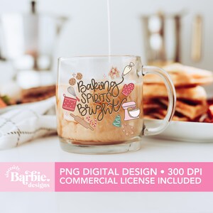 May include: A clear glass mug with the words "Baking Spirits Bright" and baking-themed illustrations. The mug contains a light brown liquid, possibly coffee or tea, and is being filled with a white liquid. The mug has a handle and is on a white surface.