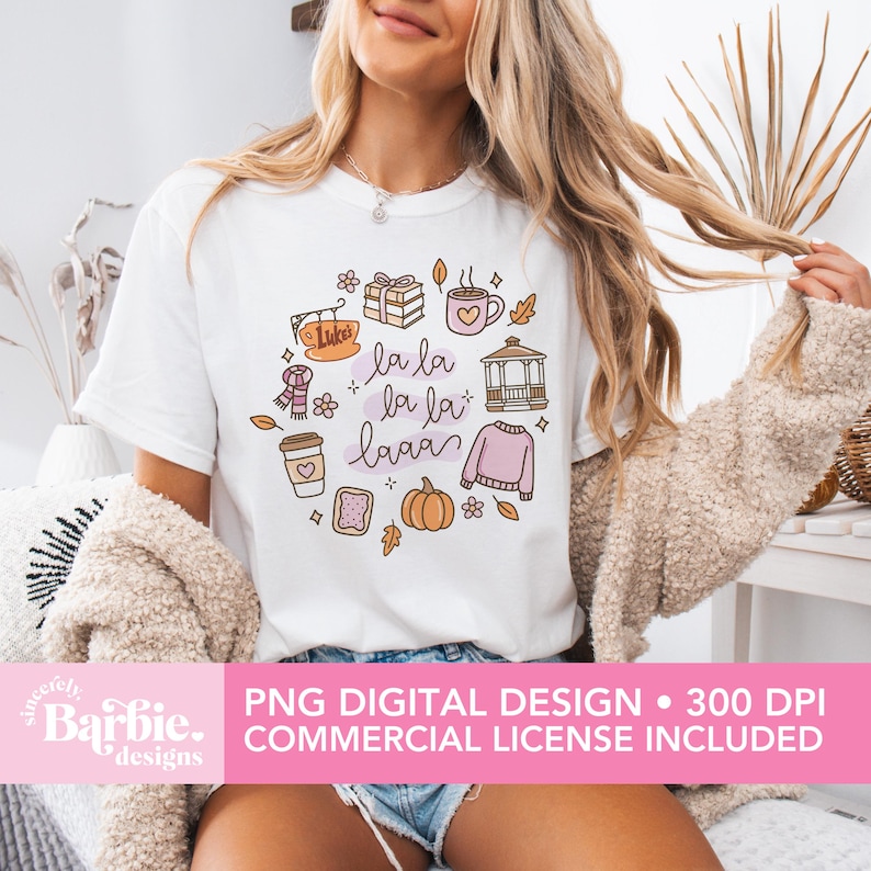 May include: White t-shirt featuring a colorful autumn-themed graphic with the text "la la la la la laaa". The design includes illustrations of a coffee cup, sweater, pumpkin, and other fall elements. The bottom of the image includes the text "PNG DIGITAL DESIGN &bull; 300 DPI COMMERCIAL LICENSE INCLUDED".