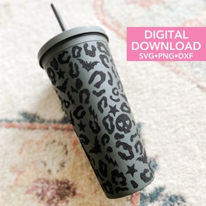May include: A grey reusable tumbler with a black and white Halloween-themed design. The design features bats, stars, lightning bolts, and leopard print.