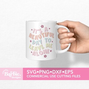May include: White ceramic mug with a pink, blue, and green design that says "It's a beautiful day to leave me alone".