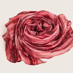 May include: A red and white striped silk scarf is folded into a rose shape.