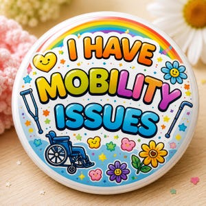 May include: A round pinback button featuring a rainbow arch at the top and the text I HAVE MOBILITY ISSUES in bold, colorful letters. The design includes a blue wheelchair, a blue crutch, a blue cane, and various small smiling flowers and stars.