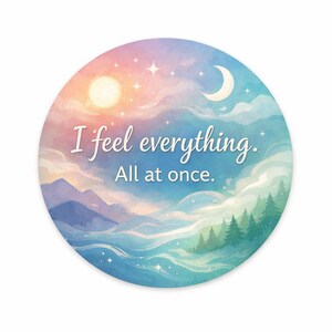 May include: Round sticker with a watercolor design featuring a sunrise, moon, and mountains. The sticker has the text "I feel everything. All at once." in a script font. The color palette includes pink, blue, and green.