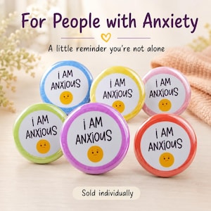 May include: Six circular badges with the text "I AM ANXIOUS" in a white circle, each with a different coloured border: blue, yellow, pink, green, purple, and red. A smiling yellow face is in the centre. The text "For People with Anxiety" is at the top.