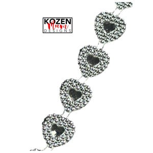 May include: A silver chain of heart-shaped embellishments, each encrusted with small, sparkling rhinestones. The hearts have a cutout heart shape in the center. The image includes the text "KOZEN Mum DESIGNS".