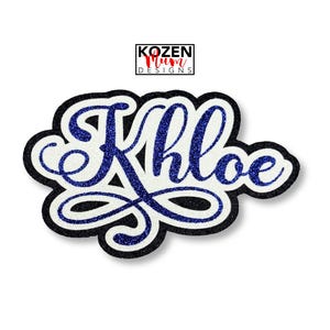 May include: A custom name patch featuring the name Khloe in a blue glitter script font. The lettering is layered over a white background with a thick black border. Above the name, a small rectangular logo displays the text KOZEN Mum DESIGNS.