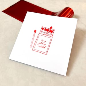 Tarjeta de amor con lámina roja brillante "Me alegro mucho de que hayamos coincidido" en una ilustración de una caja de cerillas / Tinder Bumble