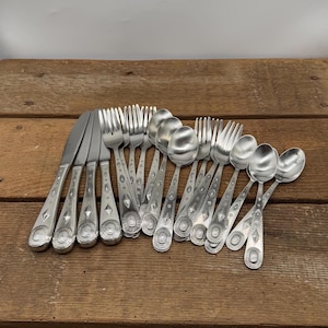 May include: A set of silverware with ornate designs on the handles. The set includes forks, spoons, and knives.