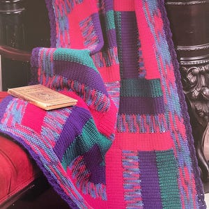 May include: A colorful patchwork quilt in shades of pink, purple, teal, and blue. The quilt is folded over a red surface, with a book resting on top. The text "Patchwork Jewels" is visible at the bottom.