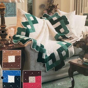 May include: A handmade, crocheted blanket with a white base and green geometric patterns. The blanket is draped over a sofa with white pillows. The edges have a scalloped trim. Small color swatches of the blanket's design are shown in the lower left corner.