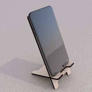 May include: A black smartphone is propped up on a wooden stand. The stand is made of light brown wood and has a simple design.