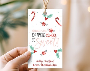 May include: White gift tag with red and green candy cane and holly designs. The text reads "thank you for making school so sweet! merry christmas from the Kennedys".