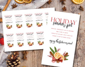 May include: Printable holiday simmer pot recipe cards with a festive design featuring red berries, cinnamon sticks, and orange slices. The cards include instructions for making a simmer pot, with the text "HOLIDAY simmer pot" in red and black lettering. The text "Pour all ingredients into a saucepan and 2 cups of water. Simmer on low heat.  Refill water as needed to keep the magic going. Enjoy the festive aroma!" is also included.