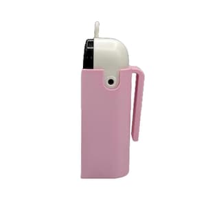 May include: A pink and white portable air purifier with a handle. The top section is white with a black vent, and the bottom is encased in a pink holder with a handle. The purifier has a small loop at the top.