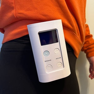 May include: White device with a digital display and buttons labeled "Massage", "Vacuum", "+", and "-".