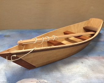 Toy boat with string and play stick - clear finish.  For play indoors or out in the water.  Made with various hardwoods & plywood.