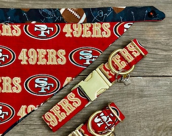 Peut inclure: Deux colliers de chien rouges et dorés avec le logo des San Francisco 49ers et le texte "49ers". Les colliers ont des boucles et des anneaux en D dorés.