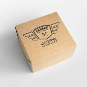 Puede incluir: Una caja de cart&oacute;n marr&oacute;n con un logotipo que dice "Garage Complete Auto Repair" y un gr&aacute;fico de una llave inglesa y un destornillador con alas. El texto "Car Service Place Your Text Here" est&aacute; impreso debajo del logotipo.