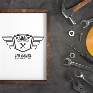 Puede incluir: Una impresi&oacute;n enmarcada con un logotipo en blanco y negro para un garaje. El logotipo presenta un escudo con las palabras "Garage Complete Auto Repair" y llaves inglesas cruzadas. Debajo del escudo hay alas y el texto "Car Service Place Your Text Here". La impresi&oacute;n est&aacute; rodeada de varias herramientas y un casco amarillo.