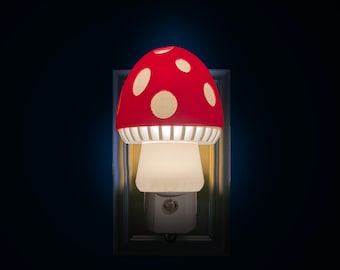 May include: A whimsical mushroom-shaped night light. The red cap features white polka dots, and the base is a soft white. The night light plugs directly into a wall outlet, offering a charming and functional lighting solution.