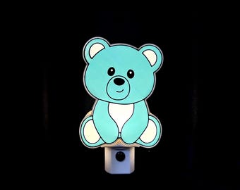 Osito de peluche con luz nocturna para niños, ideal como regalo para baby shower o habitación infantil.