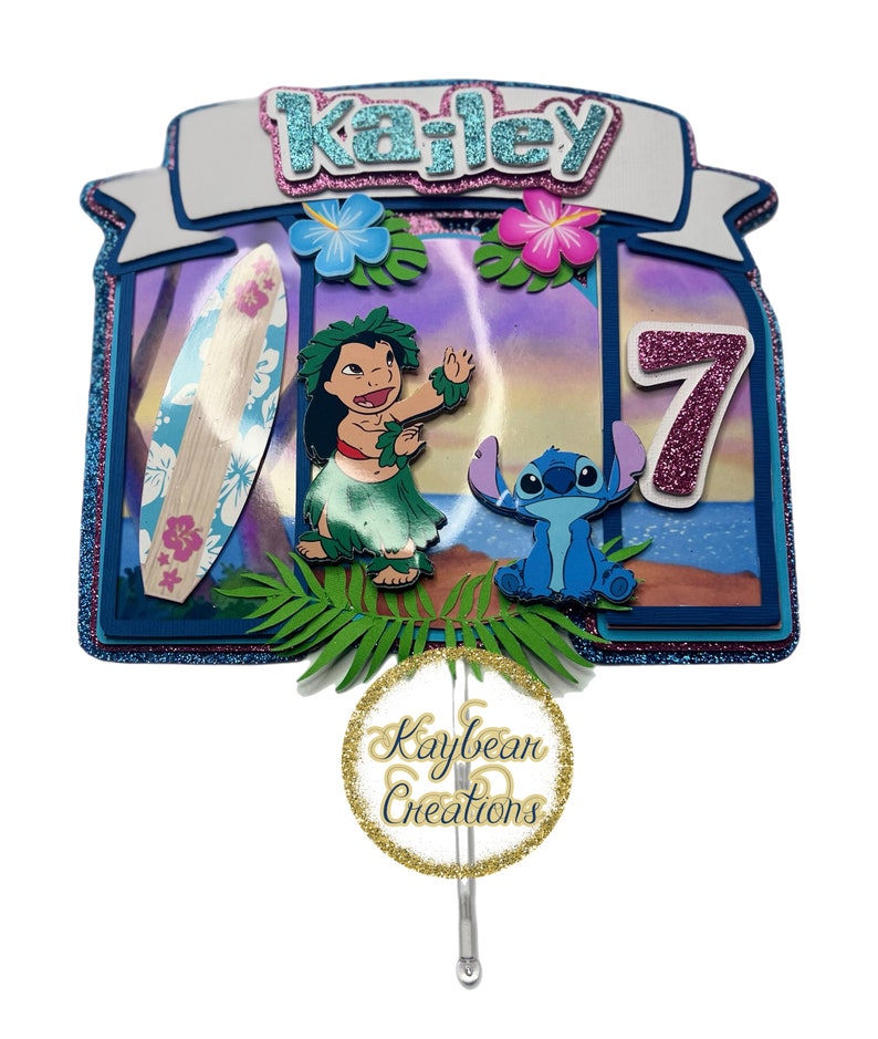 May include: A blue and pink cake topper featuring Lilo and Stitch from Disney's Lilo & Stitch. The topper includes a surfboard, flowers, and the name "Kailey" with the number "7" in pink glitter. The topper is made by Kaybean Creations.