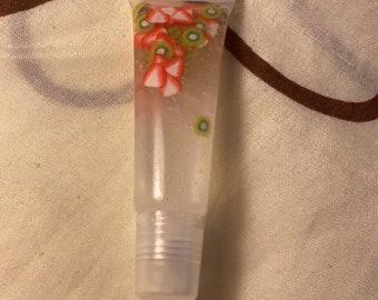 Clear Lip Gloss with strawberry and kiwi fruit slices. Smells just like strawberry kiwi. Curtly free, sanitary and homemade.