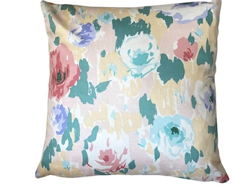May include: A floral patterned pillow with a light yellow background and pink, blue, and green flowers.