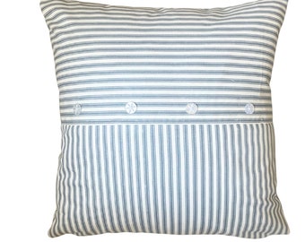 May include: A white and blue striped pillow with four white buttons. The pillow is made of a soft, woven fabric.