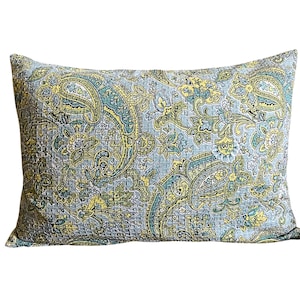 May include: Rectangular decorative pillow with a paisley pattern in shades of blue, yellow, and green. The pillow features a quilted design and a detailed floral motif, suitable for home decor.