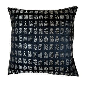 May include: Black pillow with a gold embroidered pattern of the Chinese character for "fortune" repeated across the fabric.