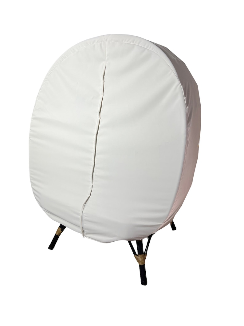 May include: White egg-shaped chair cover with a zipper down the back. The cover is made of a soft, white fabric and has a simple design. The chair has black legs with a brown rope detail.