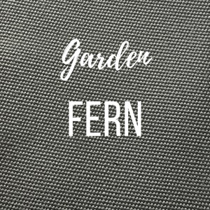 May include: A close-up of a gray, textured fabric with the words "Garden Fern" printed in white.
