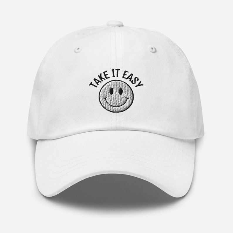 May include: White baseball cap with black embroidered text that reads "Take It Easy" and a smiley face.