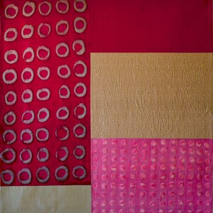 May include: Abstract art quilt with a red, gold, and pink color scheme. The quilt is made up of three sections, each with a different pattern. The left section features a repeating pattern of circles, the middle section has a textured gold fabric, and the right section has a repeating pattern of small pink circles.