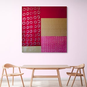 May include: Abstract art painting with a red, pink, and gold color scheme. The painting features a geometric pattern of circles and squares.